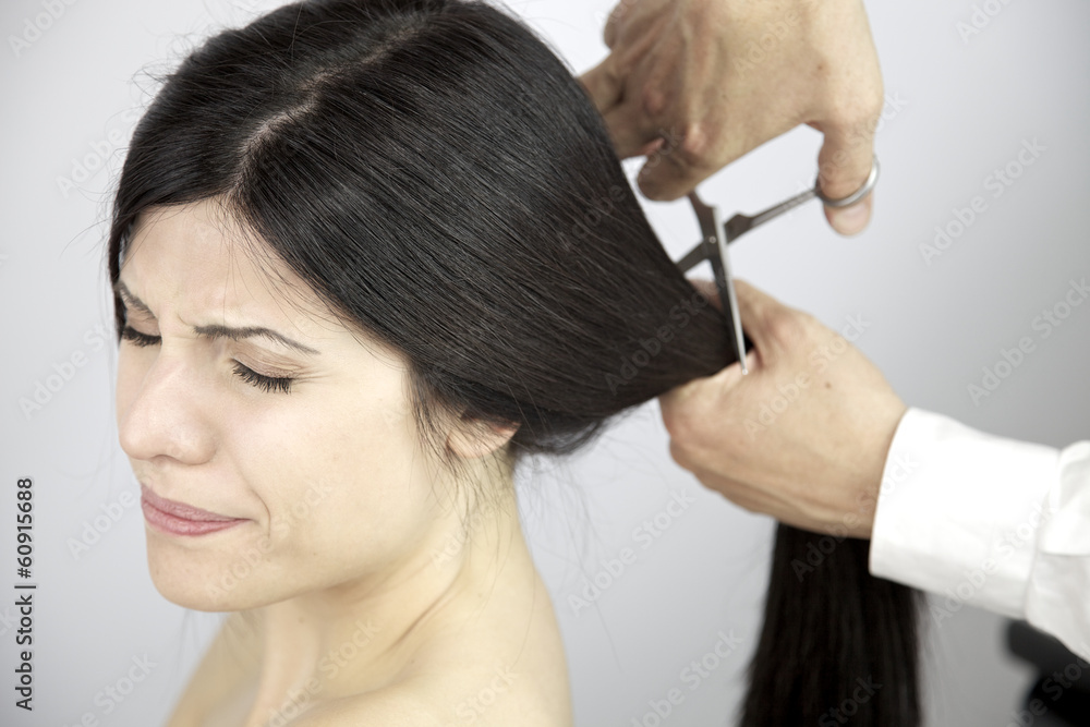 Fototapeta premium Scary moment long hair being cut by hairdresser