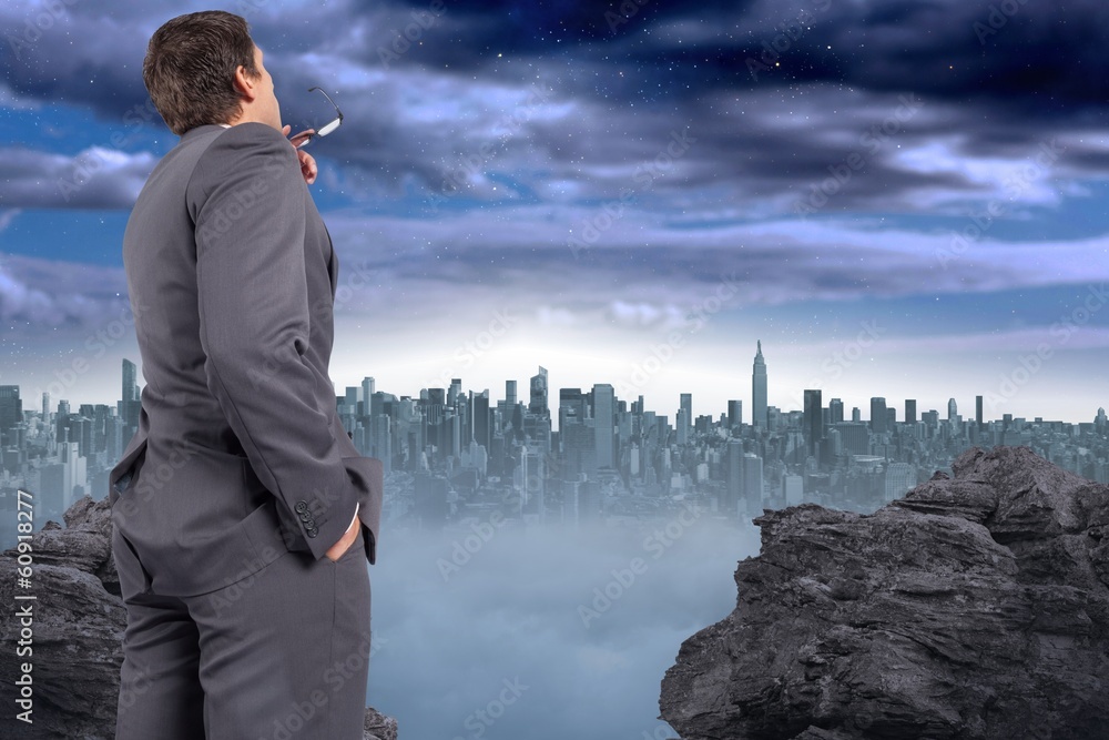 Composite image of thinking businessman holding his glasses Composite image of thinking businessman holding his glasses