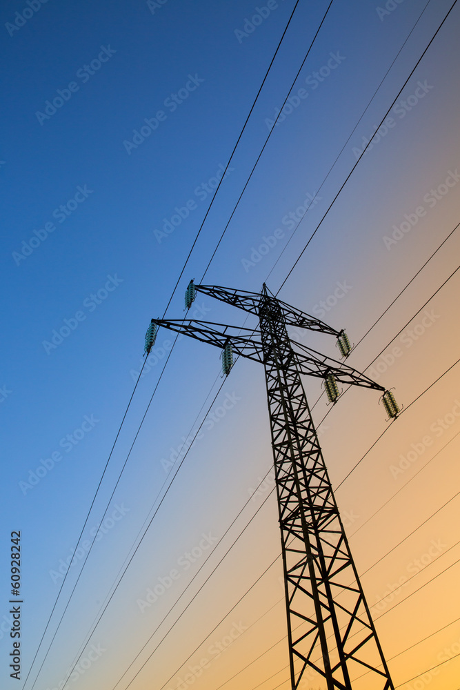 Electric power lines against blue and yellow sky
