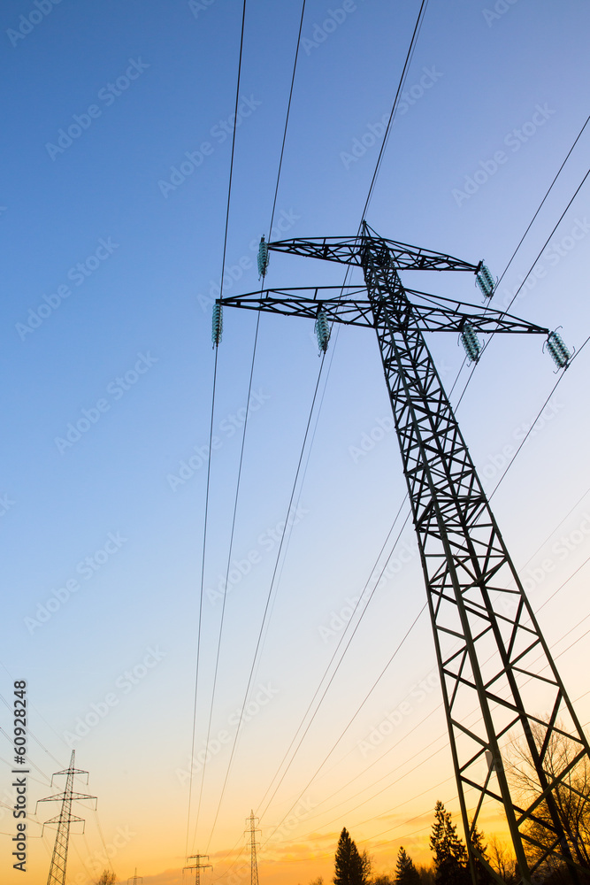 Electric power lines against blue and yellow sky Electric power lines against blue and yellow sky