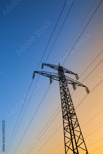 Obraz na płótnie Electric power lines against blue and yellow sky w salonie