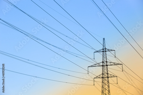 Electric power lines against blue and yellow sky
