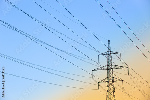 Obraz na płótnie Electric power lines against blue and yellow sky w salonie