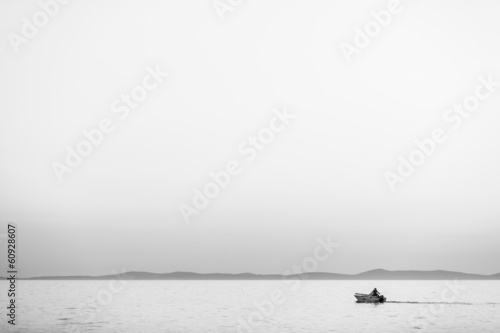 Sea panorama with isolated boat and fisherman