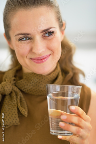 Young housewife drinking glass of water
