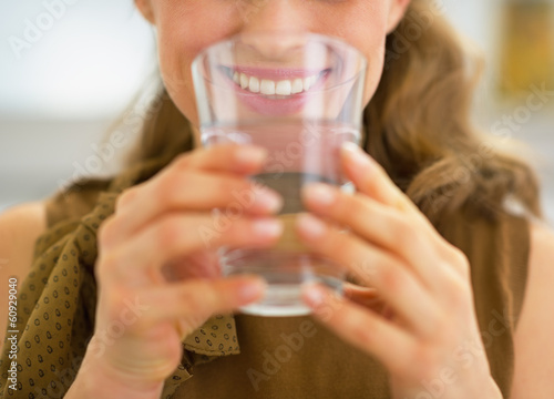 Closeup on young housewife drinking water