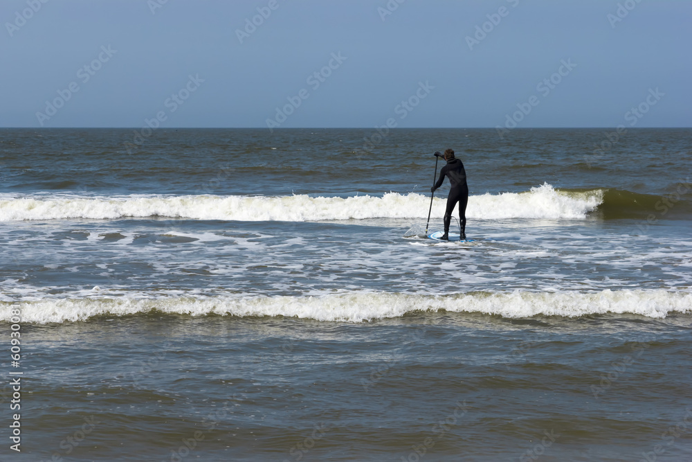 Young man in the sea on paddle board