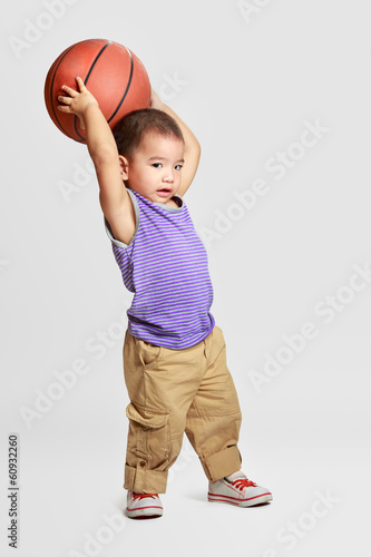 Obraz na płótnie Little boy with basketball, Isolated over grey background w salonie