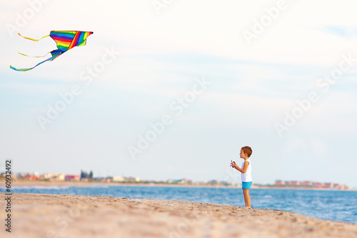 cute kid playing with kite near the seaside