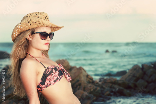 Attractive blonde with hat and sunglasses leaning backwards photo