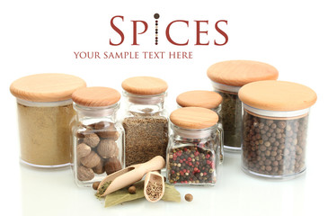 Fototapete Gewürze jars and wooden spoons with spices isolated on white  © Africa Studio