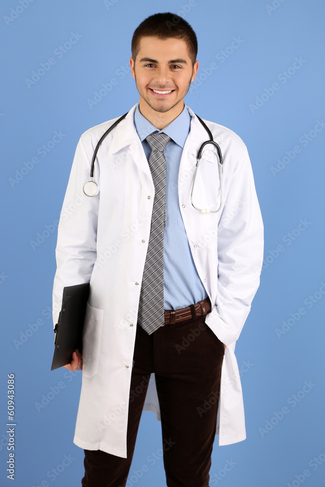 Male Doctor standing with folder, on blue background Male Doctor standing with folder, on blue background