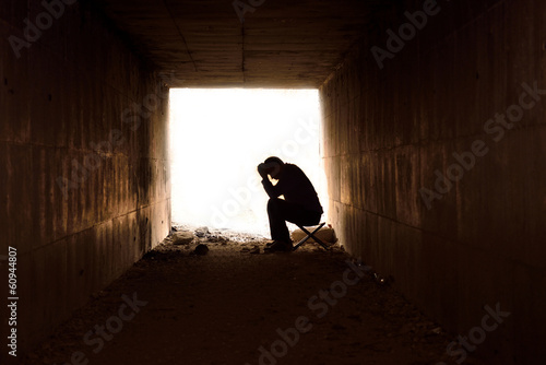 depressed man sitting in the tunnel photo