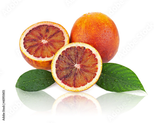 Ripe red blood oranges with cut and green leaves isolated on whi