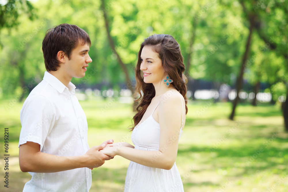 Obraz premium Young love Couple smiling under blue sky