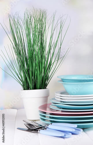 Clean dishes with flower on wooden table on natural background