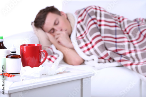 Fotografija Guy wrapped in plaid lies on sofa is ill