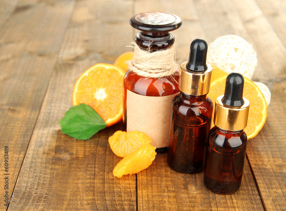 Tangerine essential oil and tangerines on wooden table Tangerine essential oil and tangerines on wooden table