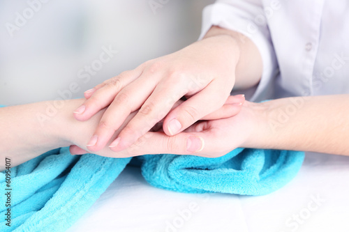 Medical doctor holding hand of patient  on light background