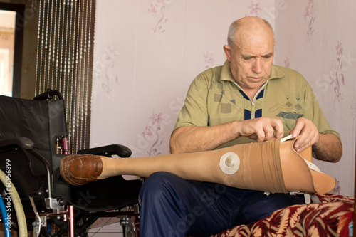 Obraz na płótnie Senior man checking out his prosthetic leg w salonie