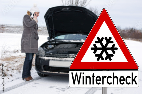 Schild Wintercheck und Frau mit kaputtem Auto photo