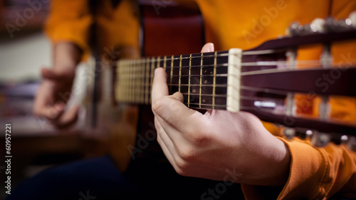 Young man playing a guitar at home and enjoys.