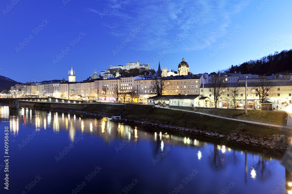 The night view on old Salzburg with medieval edifices in Altstadt district and fast flowing Salzach river, Austria