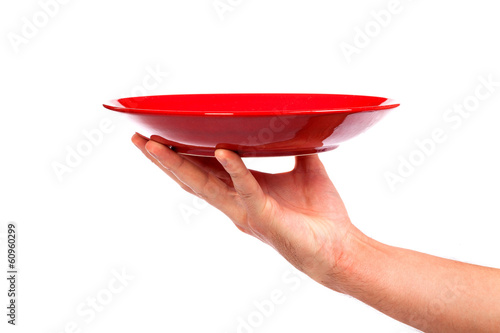 Red kitchen plate on a hand isolated