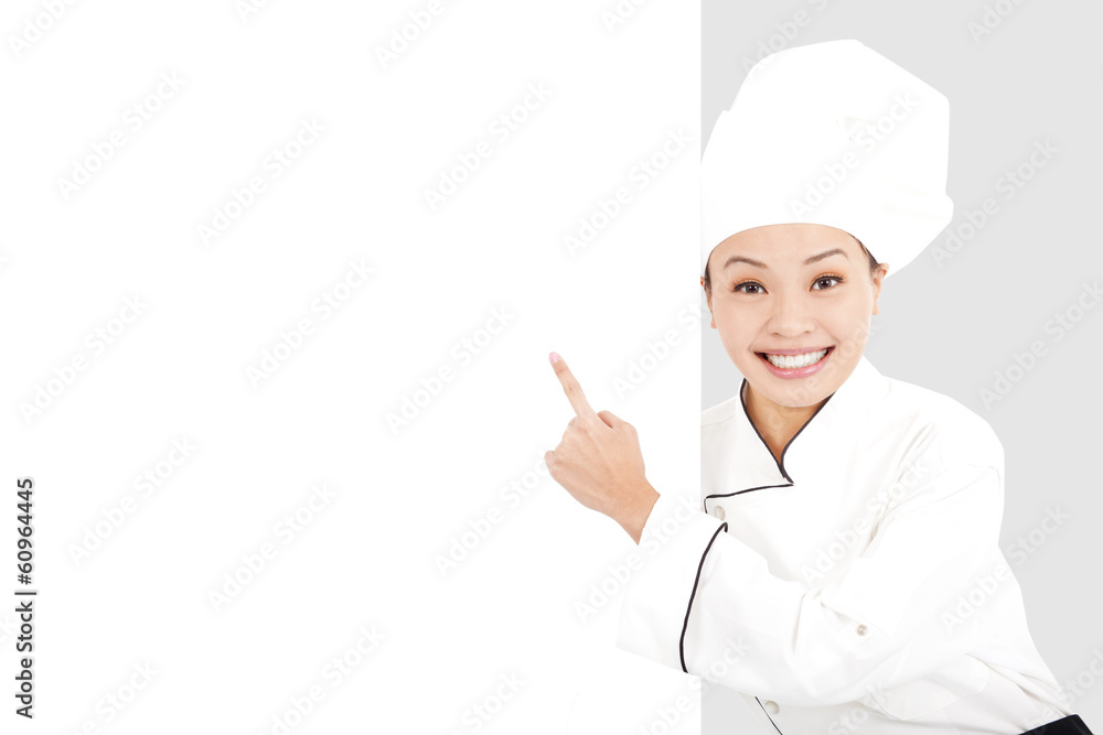 Asian smiling young woman chef pointing with blank board Asian smiling young woman chef pointing with blank board