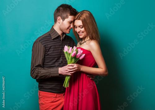 Portrait of young couple in love with flowers tulips  photo