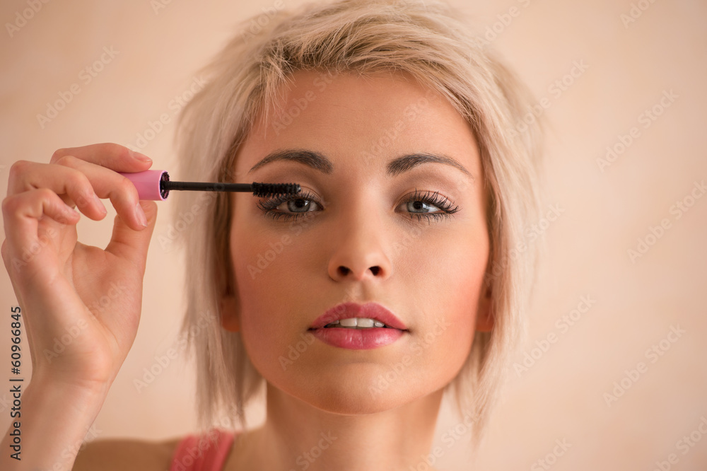Elegant blonde beauty doing makeup
