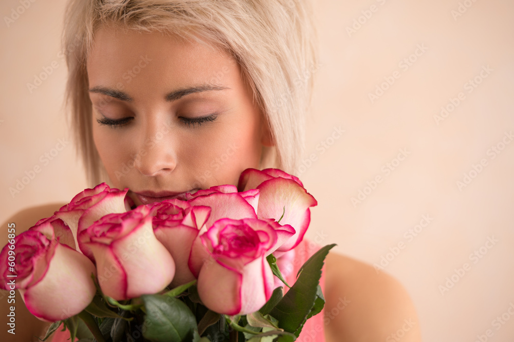 Young beautiful woman holding bouquet of pink roses