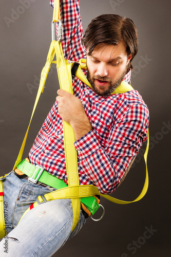 Young man wearing  a fall protection harness and lanyard for wor