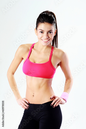 Portrait of a young smiling sport woman on gray background © Drobot Dean