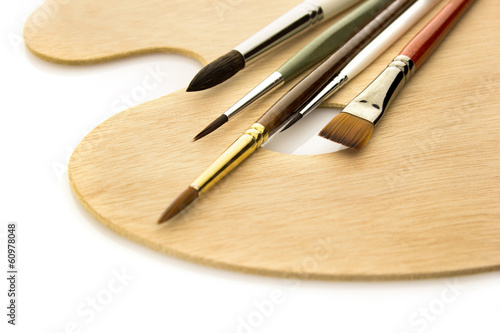 Art brushes on wooden palette isolated