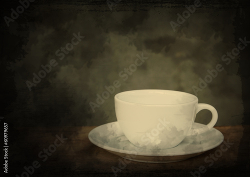 Cup of coffee on grunge wood table in vintage style