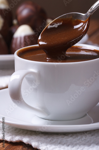 Chocolate dripping from a spoon in a cup closeup