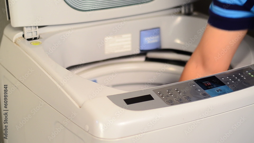 Male using washing machine Male using washing machine