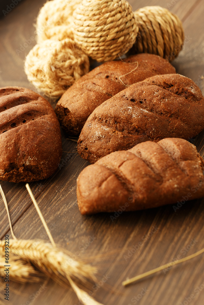 Naklejka premium Bread loaves and rope balls on wood