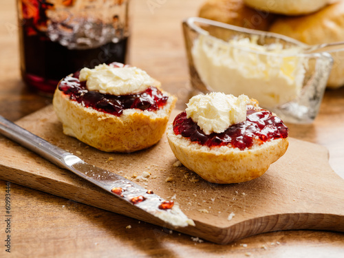 Two scones with clotted cream and jam photo