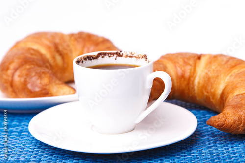 A cup of coffee and two croissants