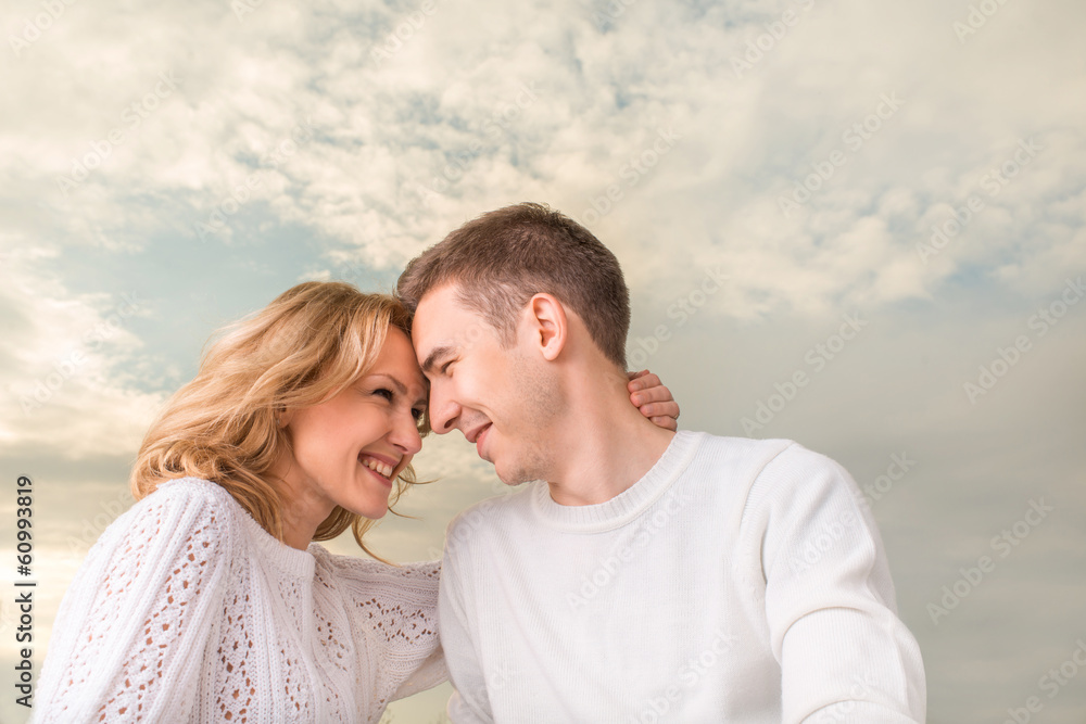 Happy couple smiling and watching one another under the sunny sk Happy couple smiling and watching one another under the sunny sk