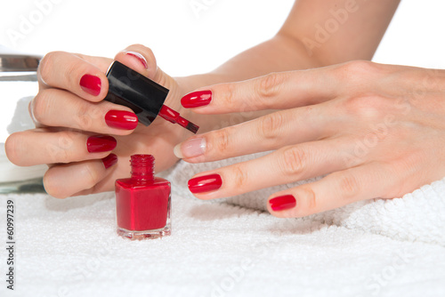 Woman hands doing manicure red nails