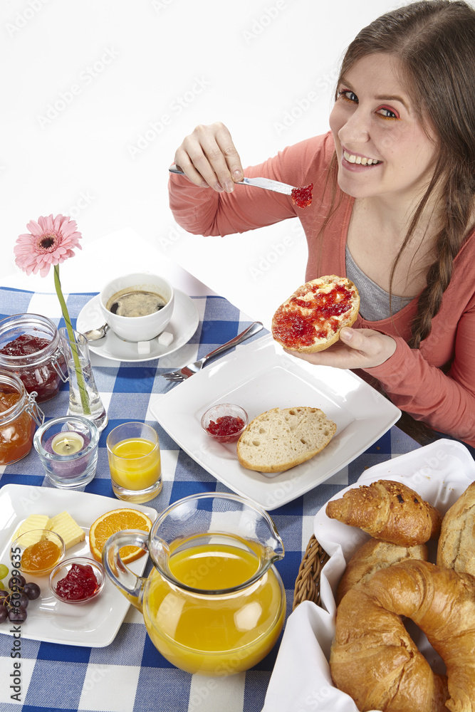 Junge Frau beim Frühstück - Brötchen mit Marmelade Junge Frau beim Frühstück - Brötchen mit Marmelade
