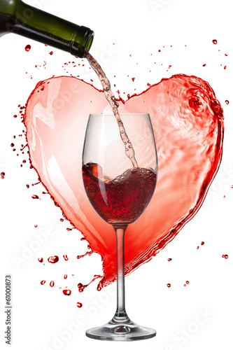 Red wine pouring into glass with splash against heart isolated o