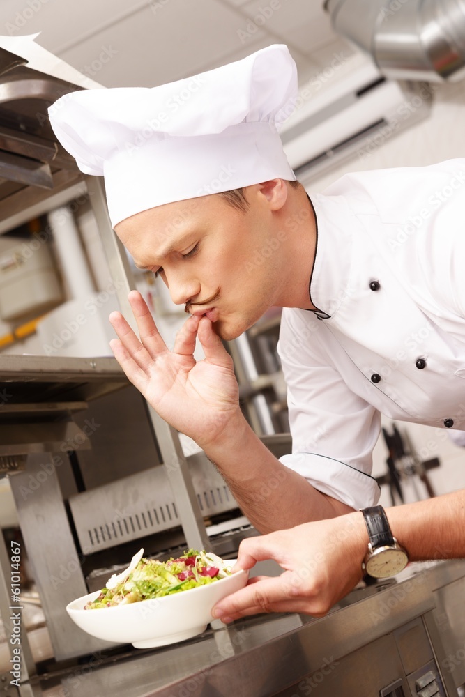 Young chief cook with gourmet food on kitchen in restaurant Young chief cook with gourmet food on kitchen in restaurant