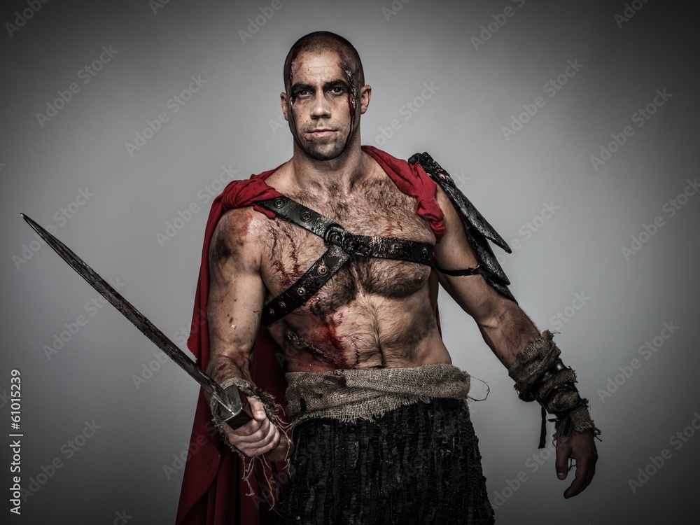 Naklejka premium Wounded gladiator with sword covered in blood isolated on grey