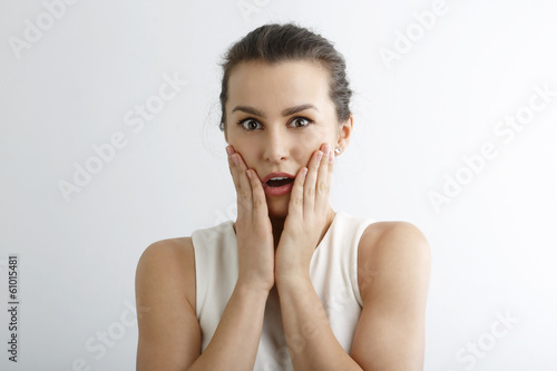 Young woman looking surprise against white background