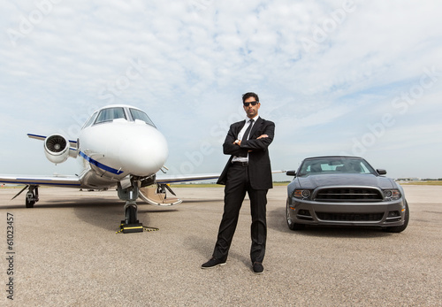 Businessman Standing By Car And Private Jet At Terminal