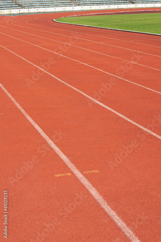 Orange racecourse with white line and green yard